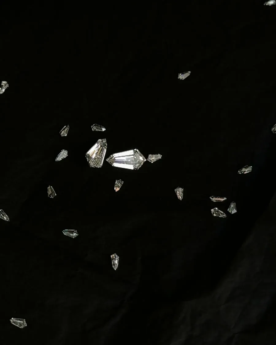 Loose cut diamonds scattered across black paper